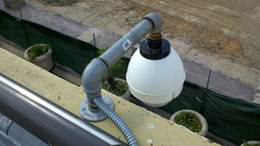 A surveillance camera mounted on the edge of a building.